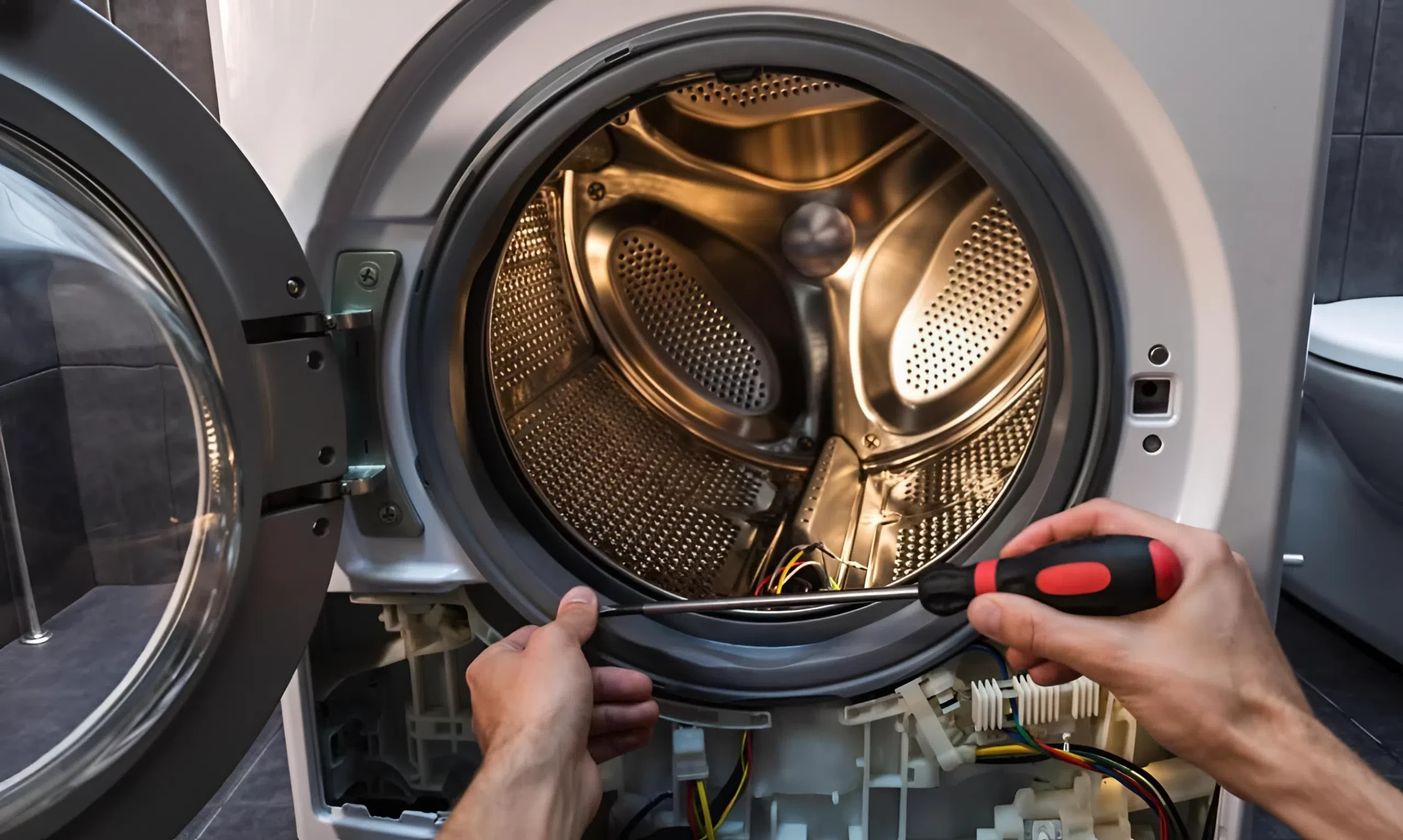Technician opening a front-loading dryer to reach the drum