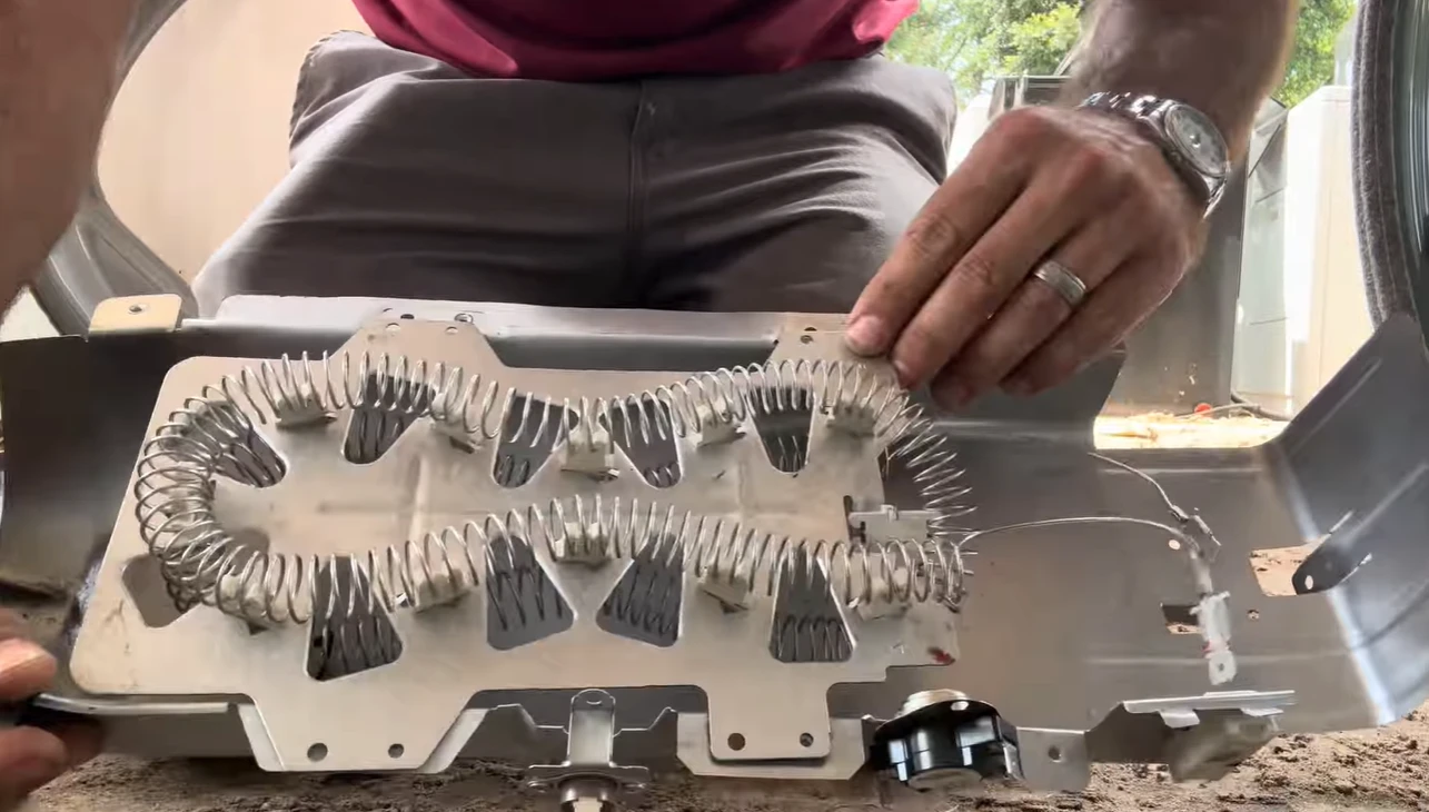 Dryer heating element assembly held in hand during a no-heat dryer repair Plano visit