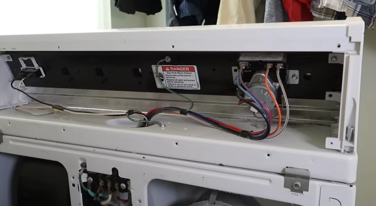 Dryer control panel removed, showing the wiring and the model label inside the cabinet