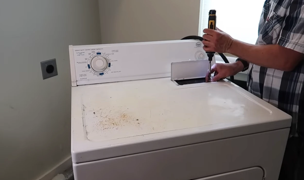 Technician testing a white dryer with a meter probe
