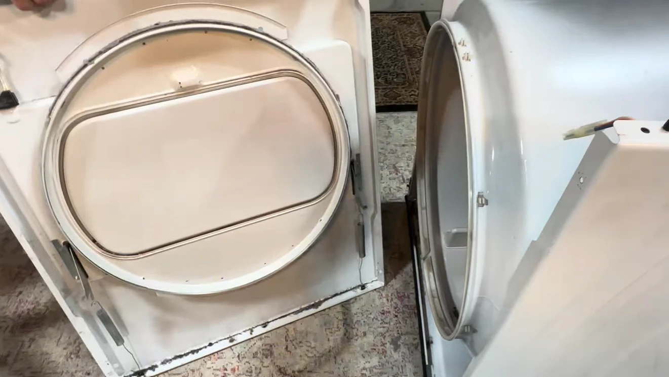 Dryer with its front panel removed, showing the drum