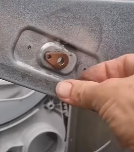 New dryer bearing held in a hand before installation